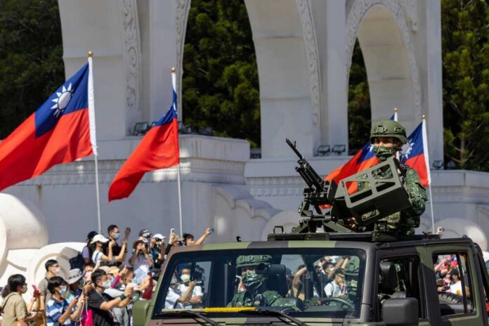 Soldiers in military vehicle during a parade with Taiwanese flags in the background