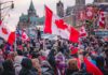 Crowd of people waving Canadian flags during an outdoor event