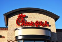 Chick-fil-A restaurant sign against a clear blue sky