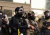 Group of police officers in tactical gear walking in an urban area