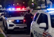 Police officers responding to an incident at night with flashing lights