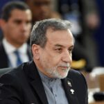 UAE Denies Israel Meeting Amid Iran Accusations A man in formal attire participating in a political meeting