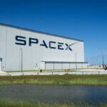 SpaceX building with American flag sky background