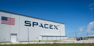 SpaceX building with American flag sky background