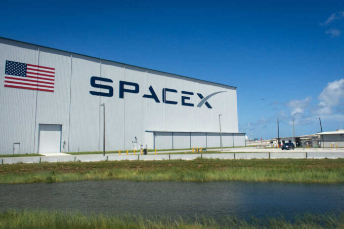 SpaceX building with American flag sky background