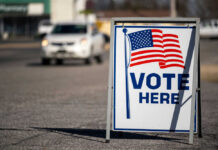 Vote Here sign with American flag.