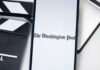 Assaults Vanish—Headlines Cry ‘Speech’ Phone displaying The Washington Post beside clapperboard.