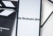 Phone displaying The Washington Post beside clapperboard.