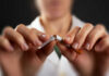 Hands breaking a cigarette in half