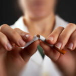 Hands breaking a cigarette in half