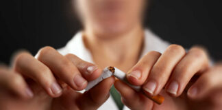 Hands breaking a cigarette in half