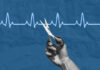 Hand holding scissors near heartbeat line illustration