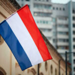 France SIZZLES — Music Fest Booze Axed Netherlands flag waving outside buildings