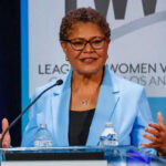Woman speaking at a podium in blue jacket