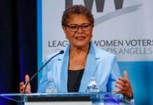 Los Angeles Runoff Drama Masks Bigger Revolt Woman speaking at a podium in blue jacket