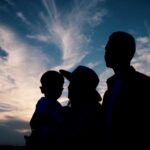 Silhouette of a family against a colorful sunset sky