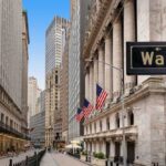 View of Wall Street with skyscrapers and American flags