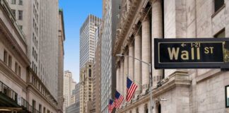 View of Wall Street with skyscrapers and American flags