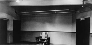 Interior view of a courtroom with wooden benches and large murals