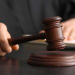 Police Chief Indicted — 70 Shocking Counts A judge's hand holding a gavel above a wooden block