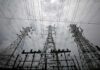 High-voltage transmission towers and power lines against a cloudy sky
