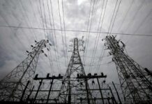 High-voltage transmission towers and power lines against a cloudy sky