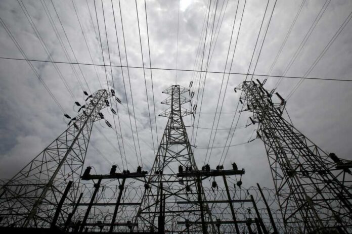 High-voltage transmission towers and power lines against a cloudy sky