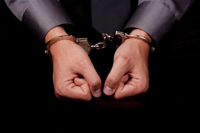 Close-up,Of,Hands,Handcuffed,,Arrested,For,Questioning. Hands in handcuffs, symbolizing arrest or detention