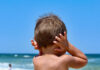 Navy Jet Roar Triggers Safety Probe child with hands on ears facing the ocean