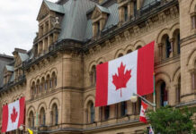 NATO Shock: Canada’s Military Hollowed Out Historic building with large Canadian flags displayed outside