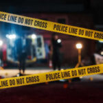 Police tape cordons off a nighttime crime scene