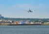 Airplane landing at busy airport near water
