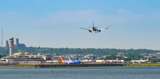 Airplane landing at busy airport near water