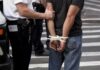 police officer detains person with hands zip-tied behind back