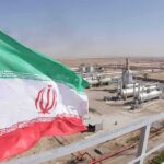 Gulf Hits? Trump Taps Iran’s Stash Iran flag over an oil and gas facility in a desert landscape