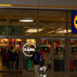 Entrance of a Lidl grocery store with customers shopping