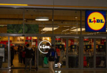 Entrance of a Lidl grocery store with customers shopping