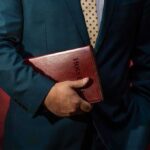 Trusted Pastor Unmasked — Horrific Child Crimes Person in a suit holding a red leather Bible
