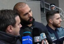 UK Extradition Twist Snags Tate Brothers Man speaking to reporters with microphones outside a building