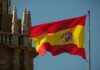Trump Slams Spain—NATO Showdown Erupts Spanish flag waving against a clear blue sky