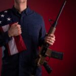 Veteran Firebrand Torches Gun-Free Myths Speaker at podium raising a fist during a conference