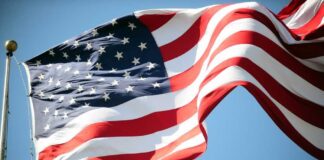 Waving American flag against a clear blue sky
