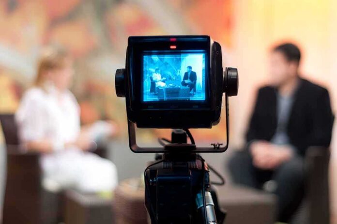 Television camera filming an interview set
