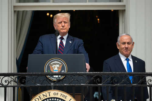 Two men standing at a podium outdoors