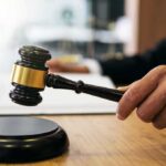 Fraud Allegation Threatens Fed Independence Judge's hand holding a gavel over a sound block