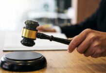 Judge's hand holding a gavel over a sound block