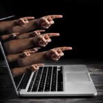 Livestream Horror Triggers Shaming Backlash Laptop with multiple hands pointing from the screen