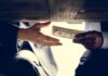 Hands exchanging cash under a table