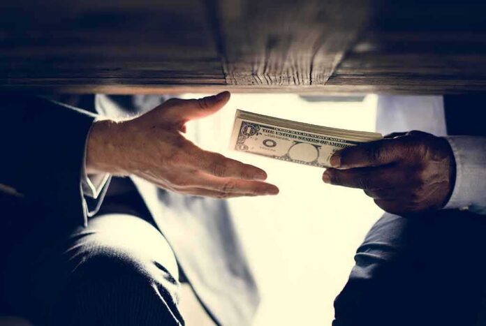 Hands exchanging cash under a table