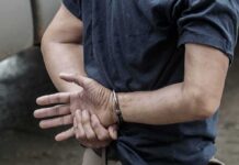 Mugshot Match Nails Repeat Border Crosser person in handcuffs with hands behind back
